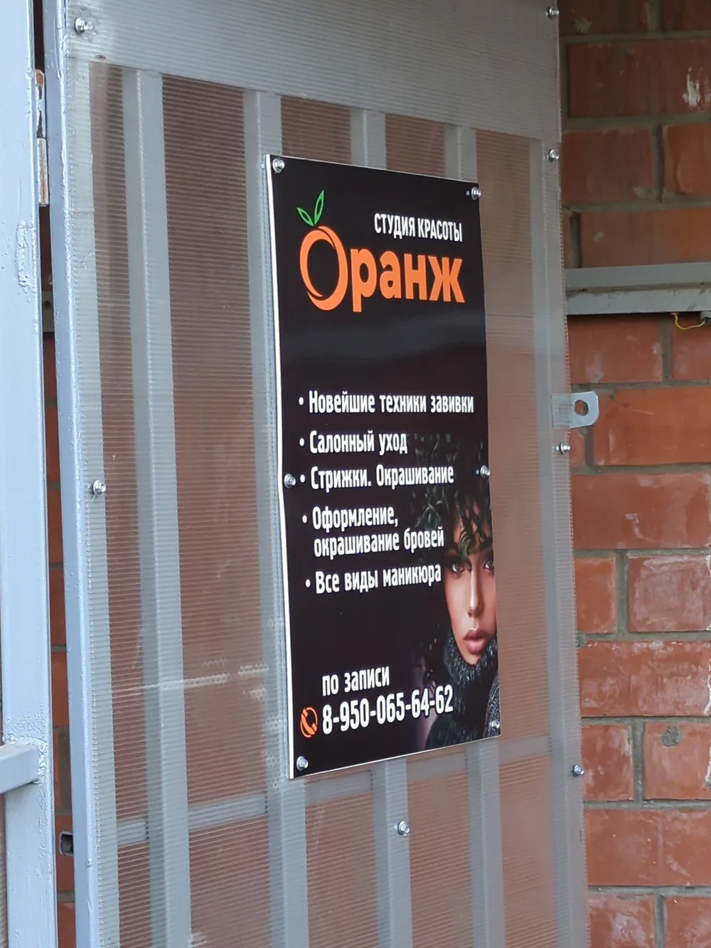 Вывеска студии красоты «Оранж» на входе